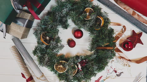 making christmas wreath in timelapse,top view pretty women hands making wreath in lamplight