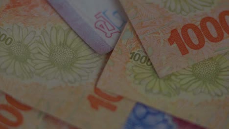 close-up of argentinian bills of different denominations in slow motion, panning left to right