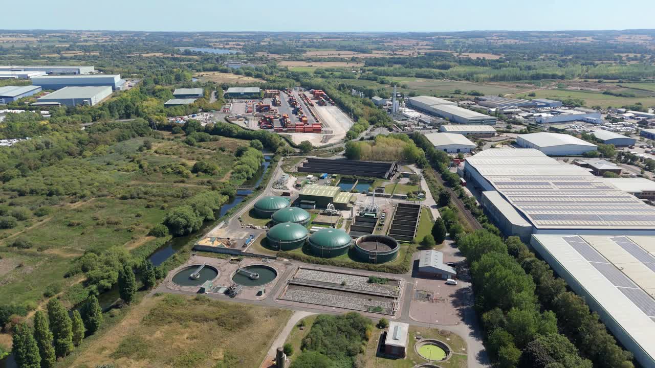 Aerial drone view of waste water sewage treatment plant, water storage silos and infrastructure in Birmingham England UK rolling green landscape