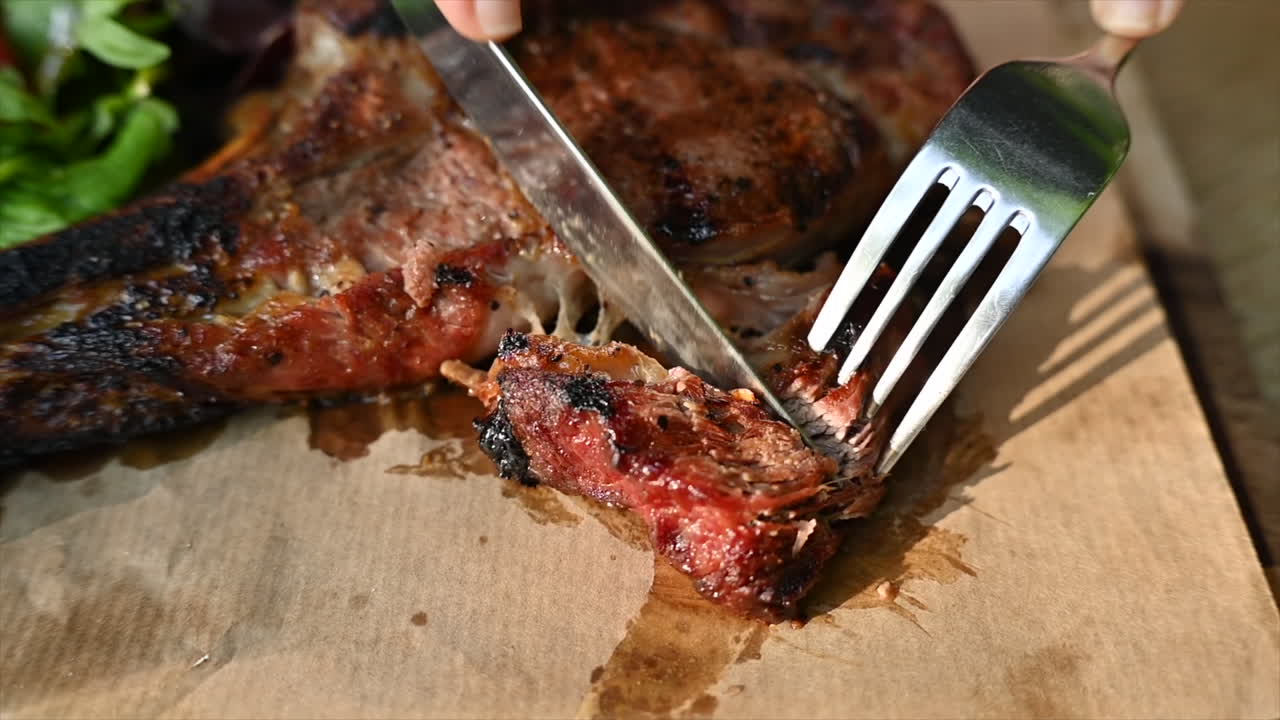 Woman eating beef stake at a restaurant with vegetables