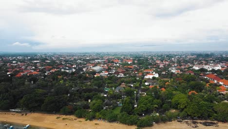 Beautiful-cinematic-Sanur-beach,-Bali-drone-footage-with-interesting-landscape,-fishing-boats,-village-houses,-hotels,-resorts-and-calm-weather