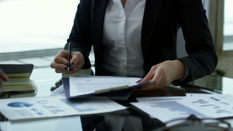 mujer de negocios en una reunión con compañeros de trabajo sentados en una mesa