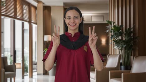 happy indian female housekeeper showing victory sign