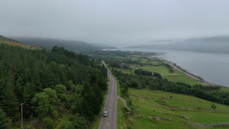 Eine-Drohne-Schoss-An-Einem-Nebligen-Tag-Hinter-Einem-Auto-Nach-Ullapool,-Schottland