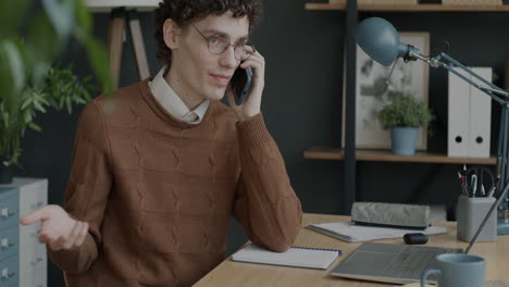 young man on a phone call in an office