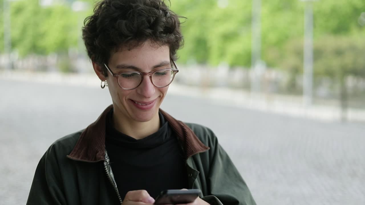 mujer feliz enviando mensajes de texto a través de un smartphone al aire libre
