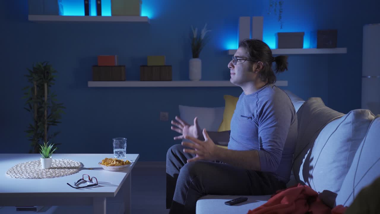 재미있는 사람이 경기를 보고 있습니다. 그는 게임에 화를 냈습니다.