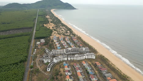 Cámara-Lenta-Drone-Subida-Pista-De-Regreso-Sobre-Complejo-Hotelero-Abandonado-En-Lang-Co-Vietnam