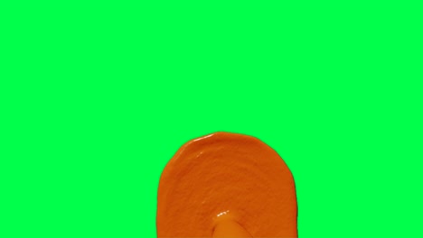 orange paint droplet on green screen