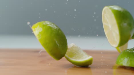 Lime-Slices-Dropping-onto-Wet-Cutting-Board-in-Slow-Motion