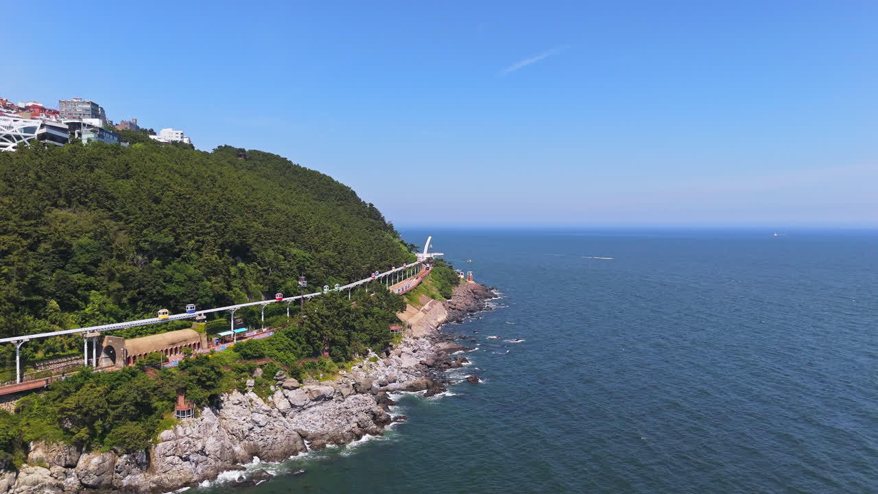 Drone rising backwards in front of the Haeundae Sky Capsule in Busan, South Korea