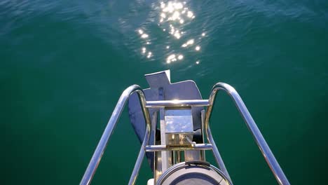 a forward moving view of a bright ship moving over a vast sea showing reflection of sun on it