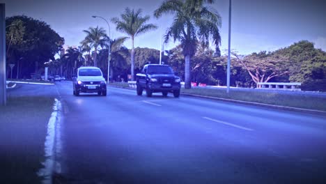 Water-spray-from-vehicles-traveling-at-dusk-along-wet-roads-after-rain