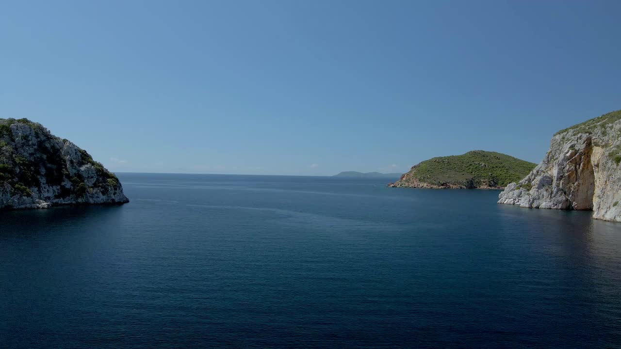 Cinematic backwards moving 4K drone clip over the tropical blue waters of Toroni in Chalkidiki