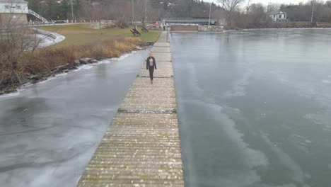 aerial drone following a young woman on a winter day