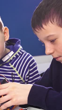 two boys building a robot together
