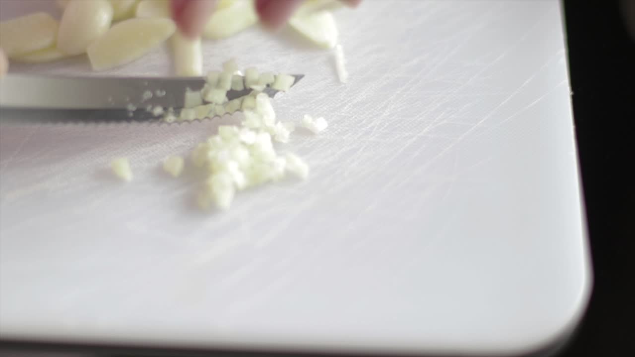 Slicing onion on very small pieces on a chopping board