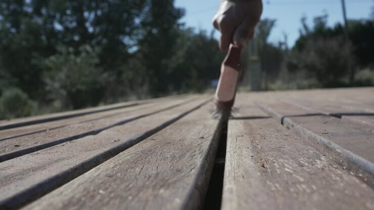 Deck maintenance. Hand brushing a wooden durface