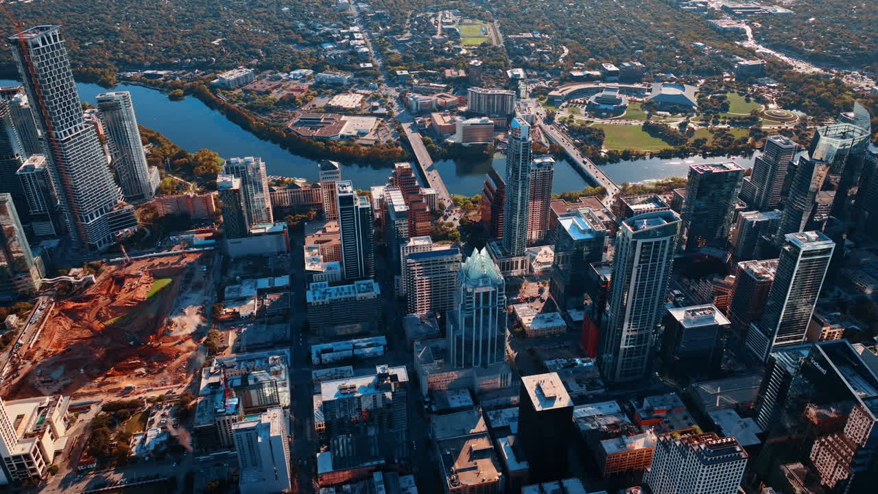 Veduta aerea dello sviluppo del centro di Austin e del fiume. Ampia prospettiva dello skyline con un cantiere e il Lady Bird Lake durante il pomeriggio.