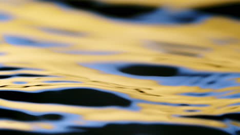 Close-up-real-of-water-drop-falls-into-water-and-diverging-circles-of-water-with-smoot-color-background-in-studio-with-copy-space-for-place-a-text-for-advertisement