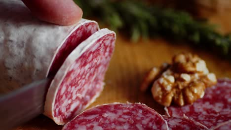 salami cut into pieces on a wooden cutting board.