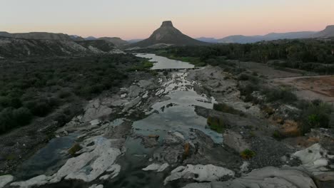 La-Vista-Aérea-Se-Aleja-Del-Tiro,-La-Vista-Panorámica-De-La-Formación-Rocosa-Y-El-Río-La-Purísima-Baja-California-Sur,-México,-Las-Montañas-El-Pilón-Al-Fondo