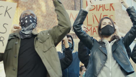 gruppo di persone multietniche che urlano in una protesta contro il razzismo in strada