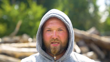 Facial-Expression-Of-Active-Man-In-Hoodie-Jacket-Lifting-Weight-Outdoor