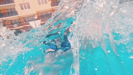 un niño bajo el agua se divierte en la piscina.