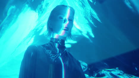 female alien in silver dress posing in blue laser light