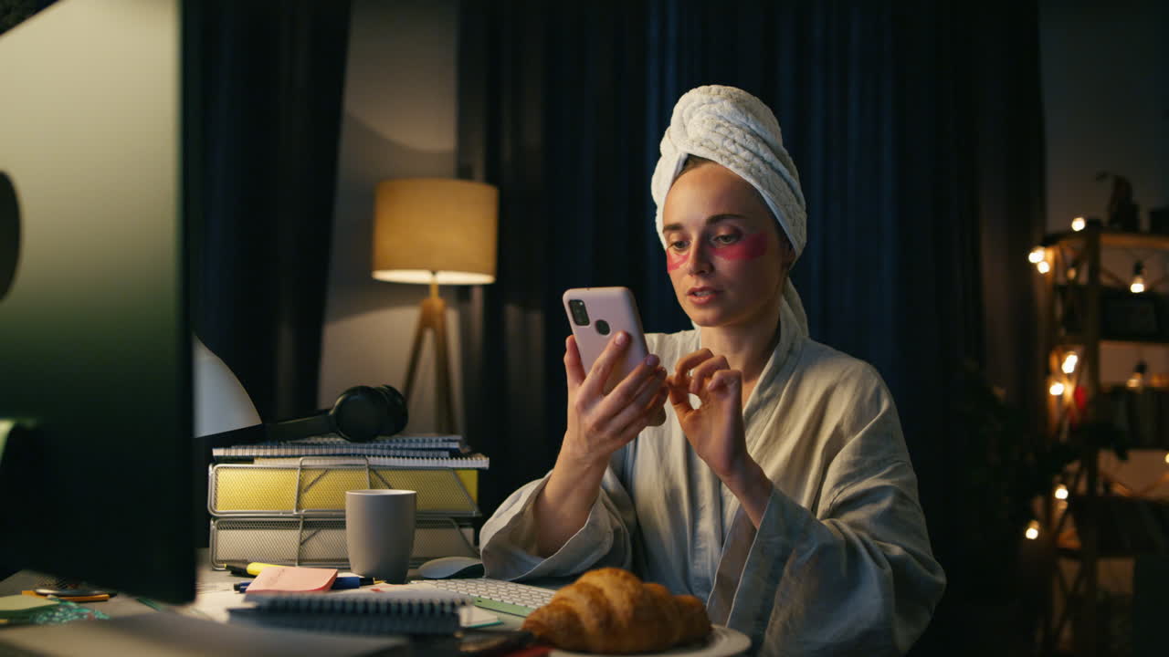 Primo piano di una donna sicura di sé che controlla lo smartphone a casa. Freelancer che parla in videochiamata.