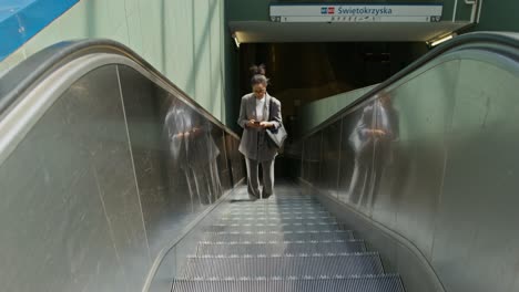 mujer en una escalera mecánica en una estación de metro