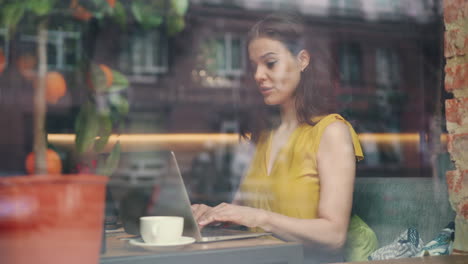 woman working on laptop in a cafe