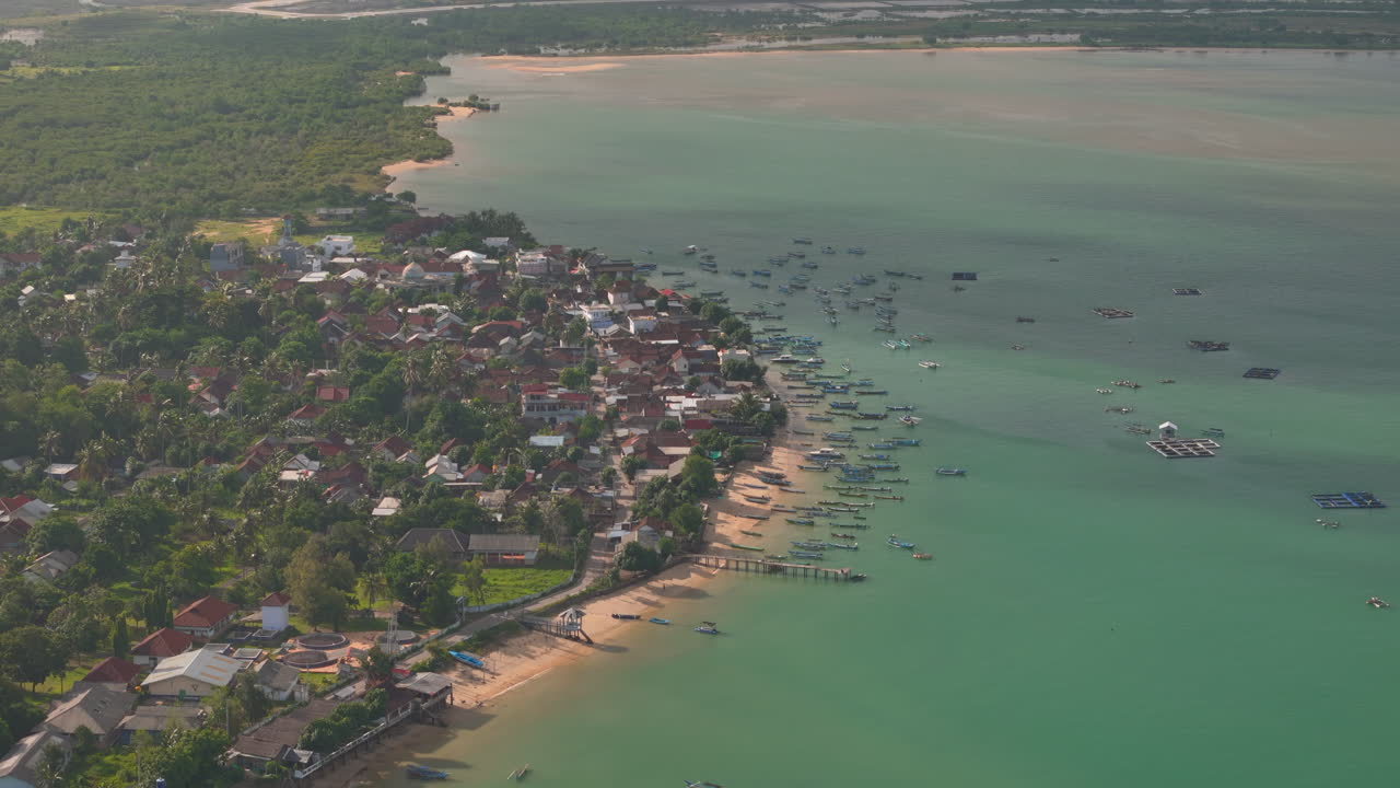pueblo costero en lombok, gerupuk indonesia, con barcos atracados por las aguas turquesas, vista aérea