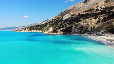 sandy beach and scenic cliffs at agia kiriaki in greece - aerial drone shot