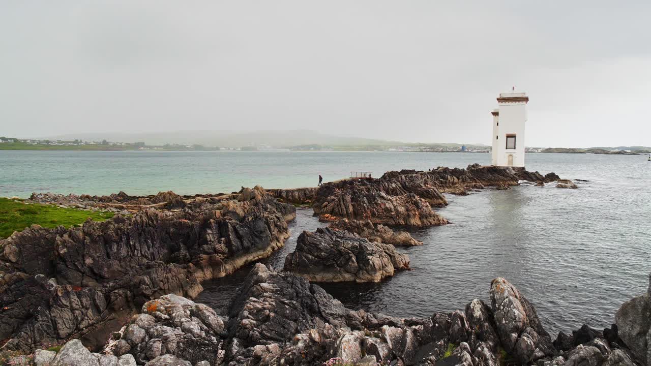 faro de carraig fhada con una tormenta de lluvia sobre port ellen en la isla de islay