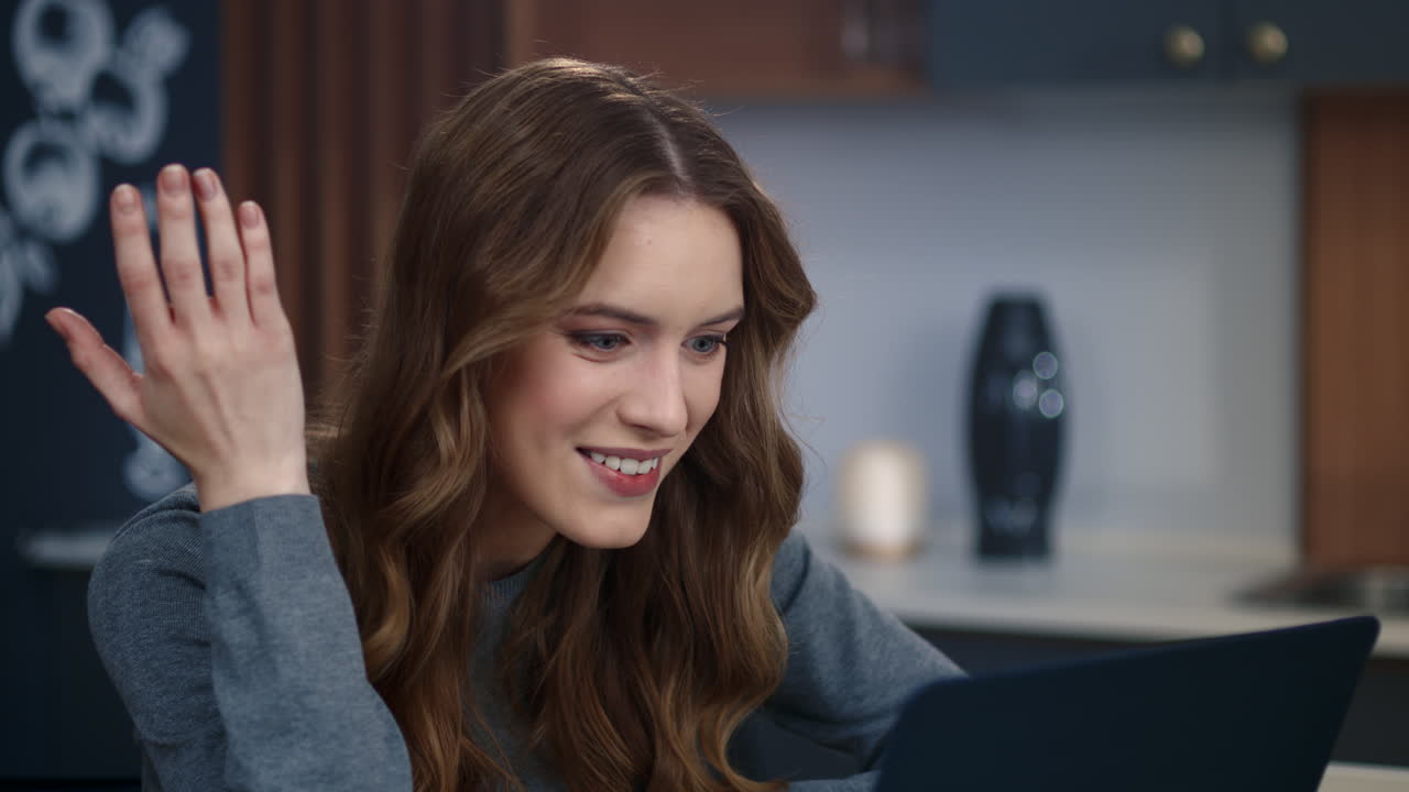 mujer de negocios emocional haciendo una videollamada en una computadora portátil en la oficina de su casa.
