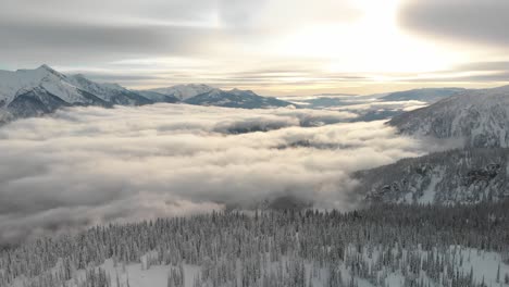 drone shot over the mt revelstoke in british columbia covered by clouds