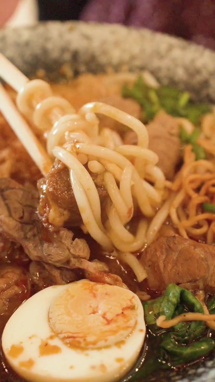 Orang Menggunakan Sumpit untuk Makan Sup Mi Daging Sapi