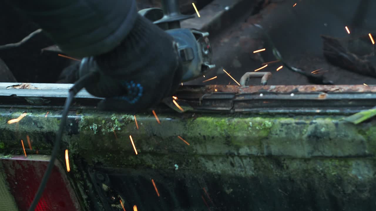 장갑을 입은 남자가 절단 디스크로 금속을 습니다. 각 가루. 금속으로 작업. 화재 스프레이. 수리 가게. 기계 조립 작업의 기계.