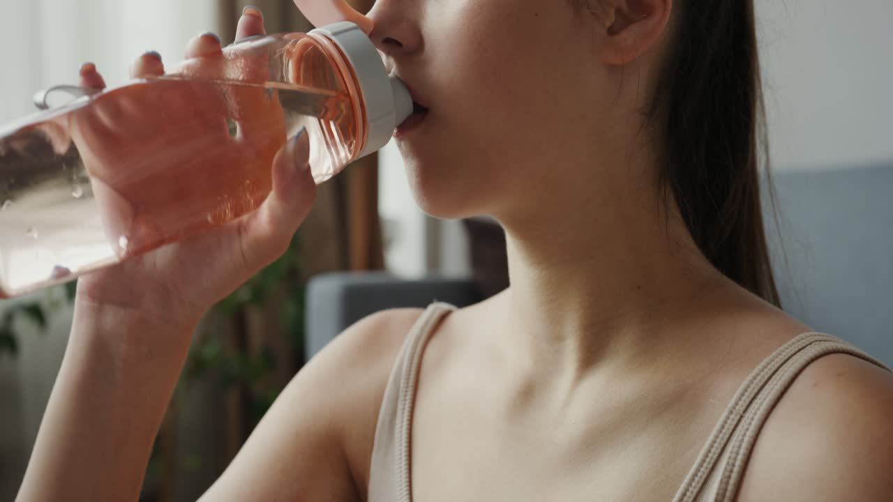 mujer bebiendo agua de una botella