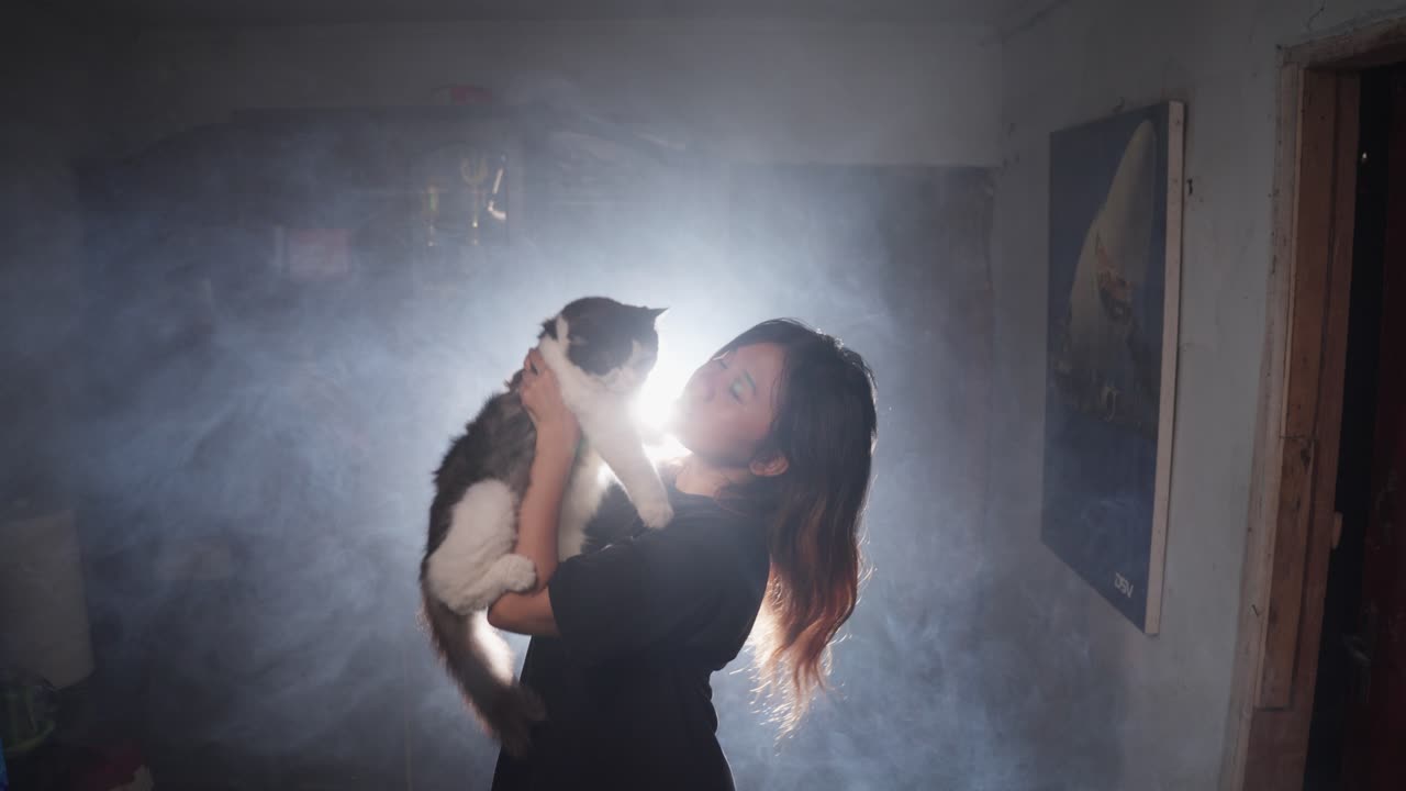una mujer feliz sosteniendo a su gato en una casa llena de humo.