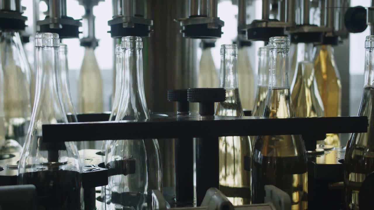 Amazing wide shot of machinery that fills white wine bottles inside a wine factory in Burgos, Spain