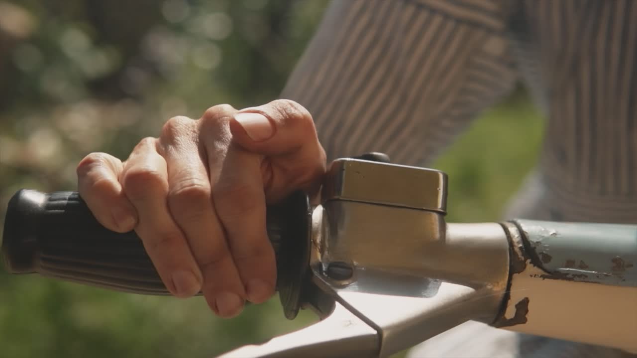 primer plano panorámico de un hombre que sostiene el manillar de un viejo clásico oxidado lambretta api scooter, india
