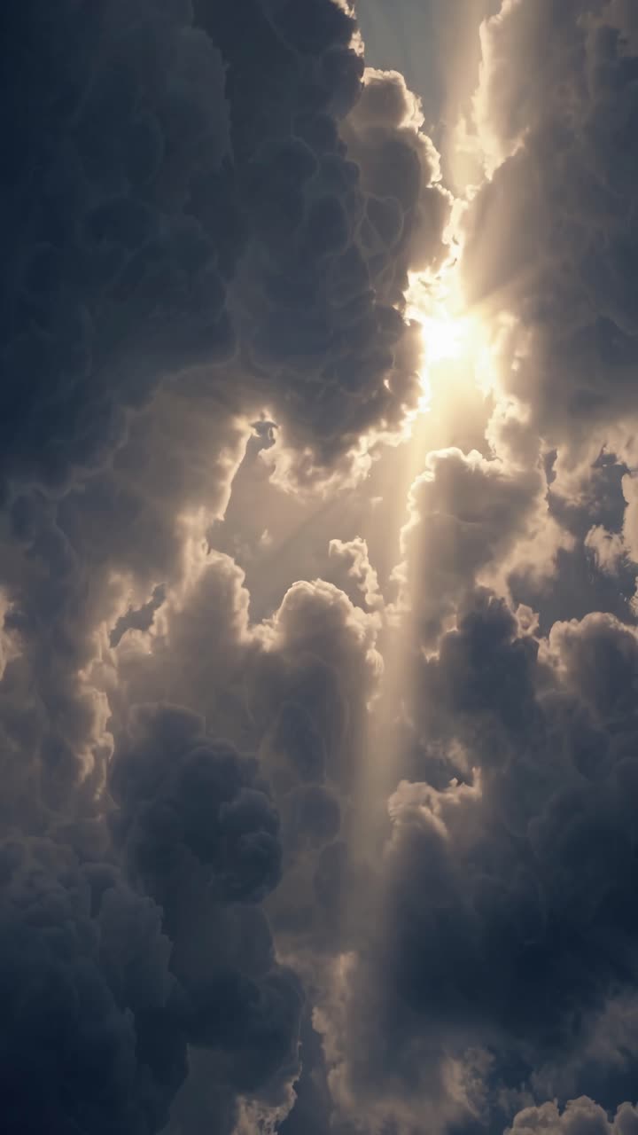Dramatic video concept of sunlight piercing through dark clouds, captured from a low angle