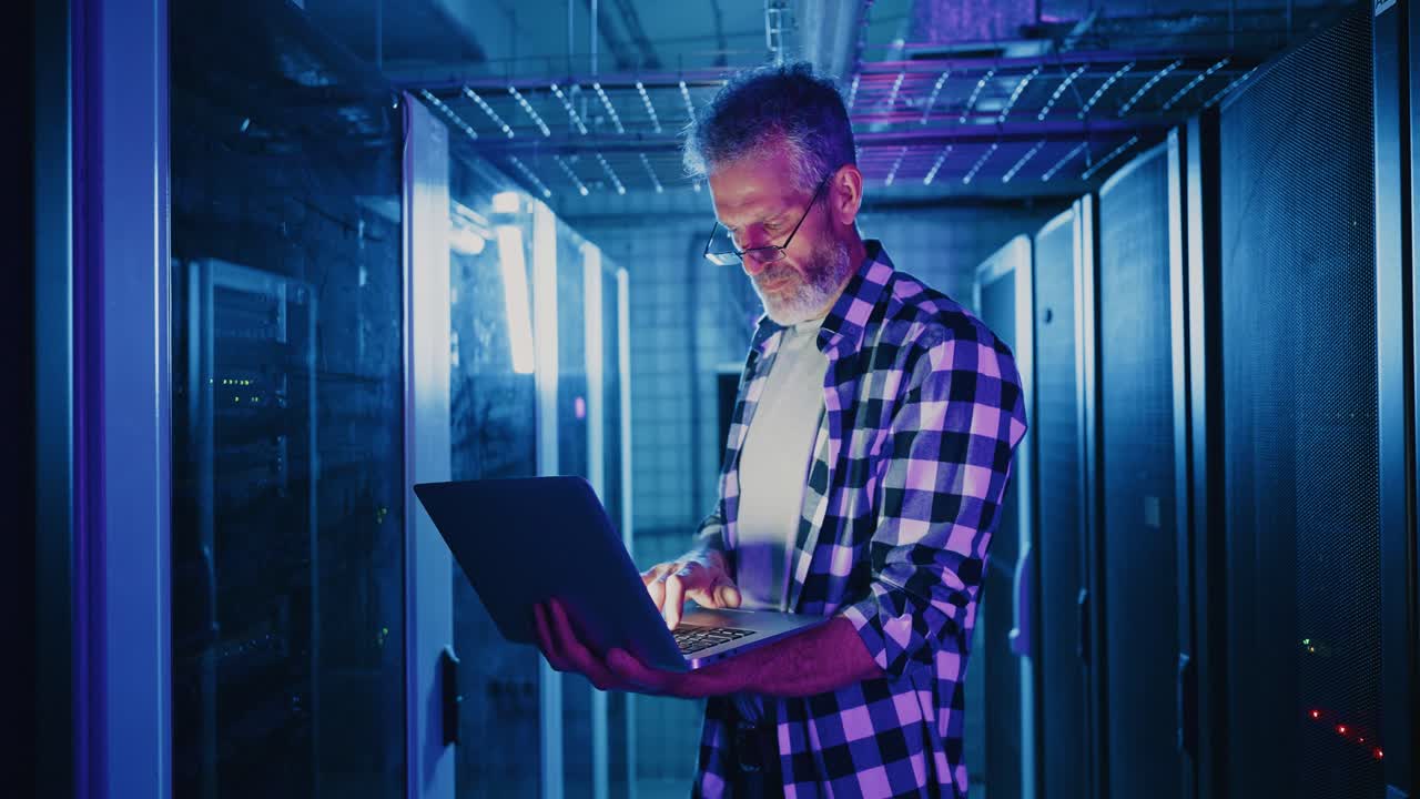 IT Professional Working in a Server Room at Night