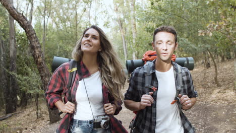 happy active travelers walking on forest path