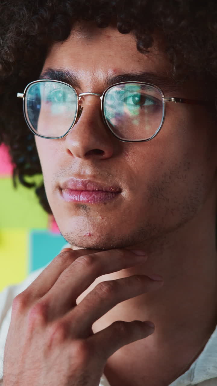 Close-up of Thoughtful Young Man Adjusting Glasses