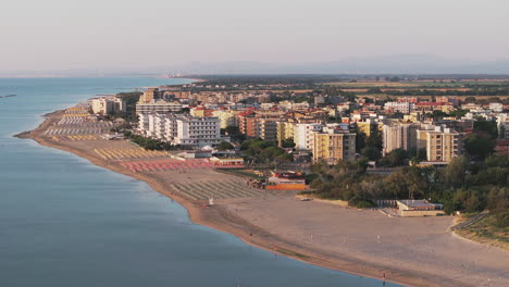 toma aérea a 24 fps de una playa de arena con paraguas, típica costa adriática