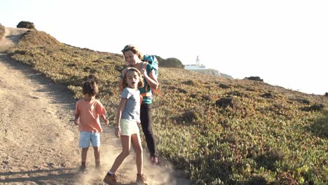 Niños-Felices-Y-Activos-Caminando-Y-Saltando-Por-Un-Sendero-De-Montaña